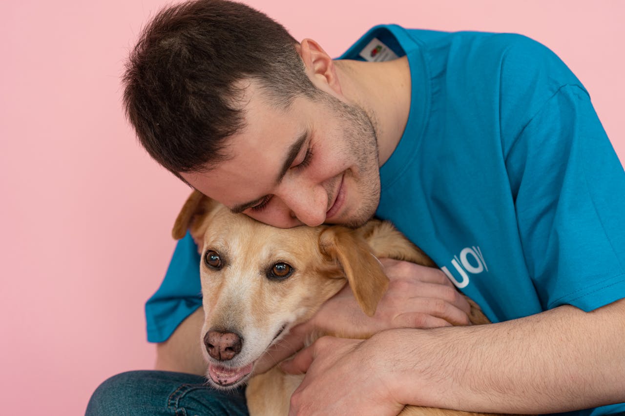 cta-02 Smiling man warmly embraces his dog, creating a heartwarming studio portrait.
